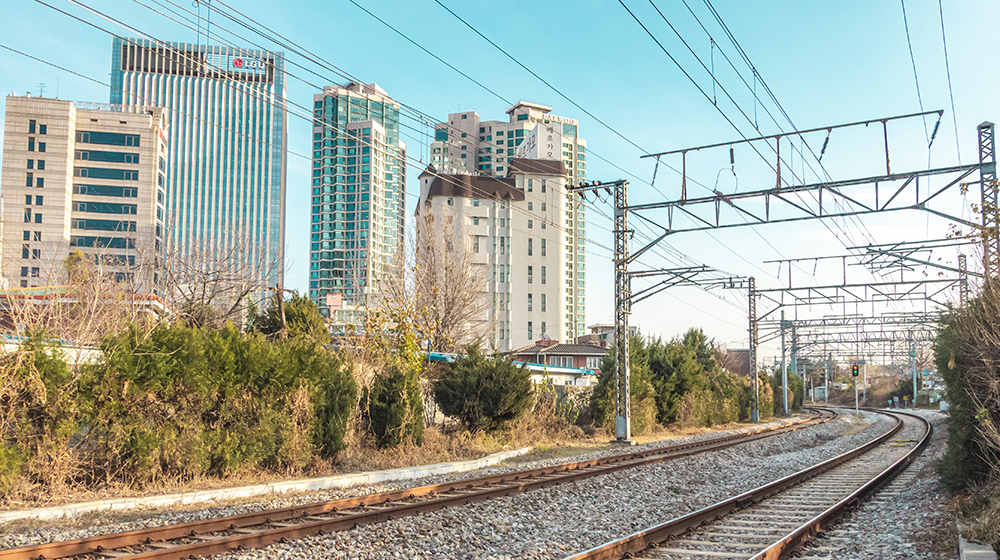 Yongsan railroad tracks with apartment complexes and LG U+ buildings off in the distance during the day