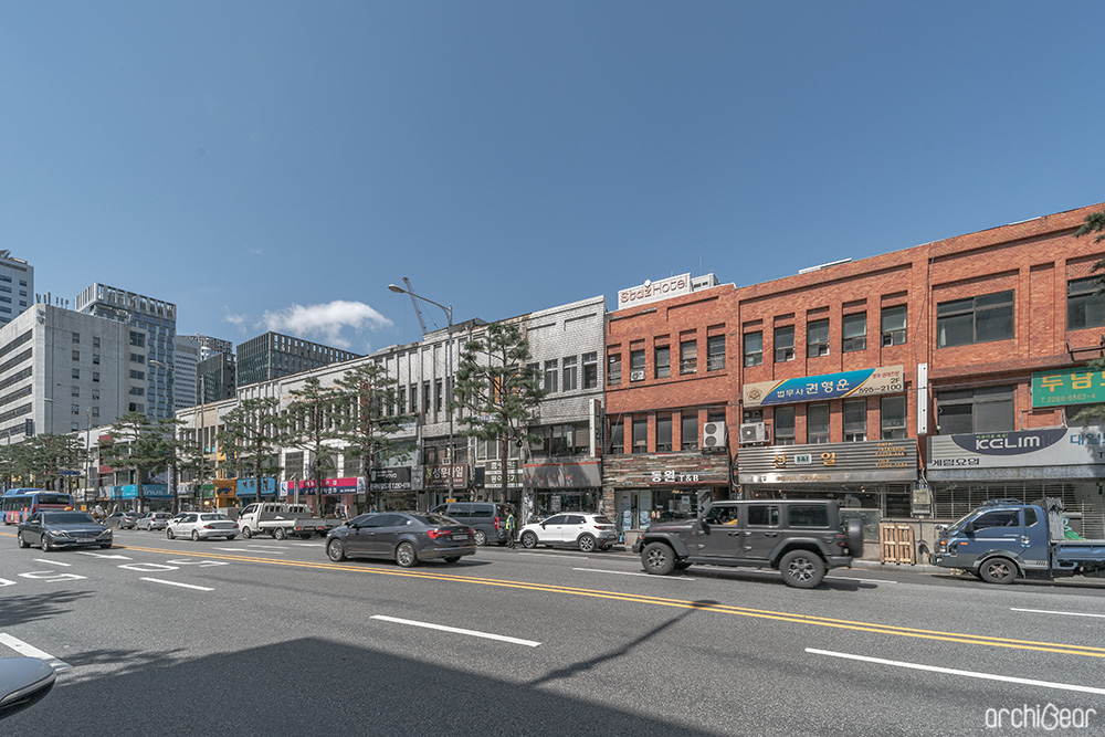 A panoramic view of Euljiro 3-ga Street. Three-story, quiet and old buildings are visible in front of you, and cars are running on a six-lane road.