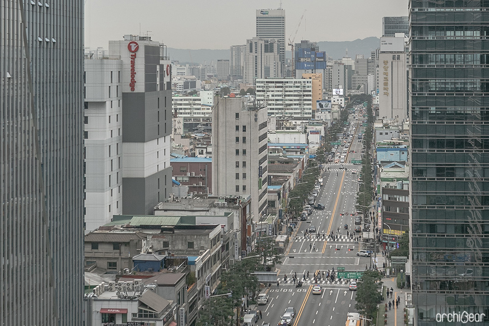 건물 옥상에서 내려다본 을지로3가 대로변. 높낮이가 다른 빌딩과 건물들이 길 양옆으로 보인다.