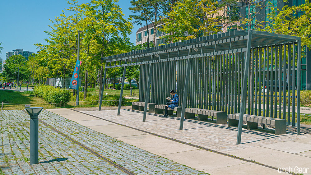 경의선 숲길 한쪽에 위치한 휴식 공간의 모습. 4개의 벤치가 설치되어있고 한 사람이 앉아서 휴식을 취하고 있다.